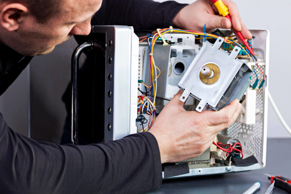 Image of a technician replacing a microwave's magnetron in Calgary, AB.